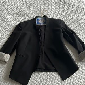 Theory black blazer with stripped interior sleeves if rolled.